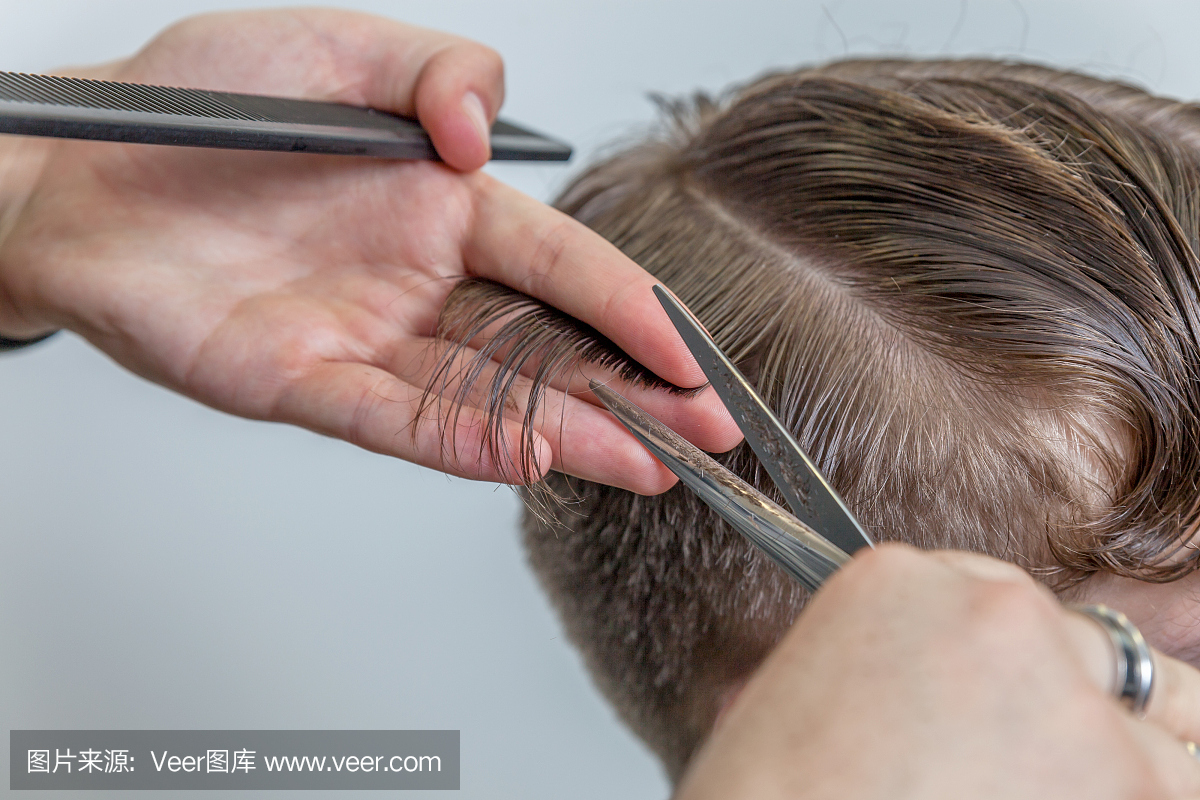 熟练的理发师修剪男性头发